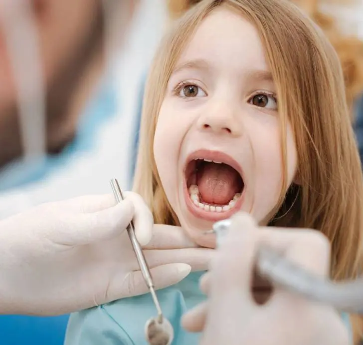 Dentist examining a little girl's teeth.